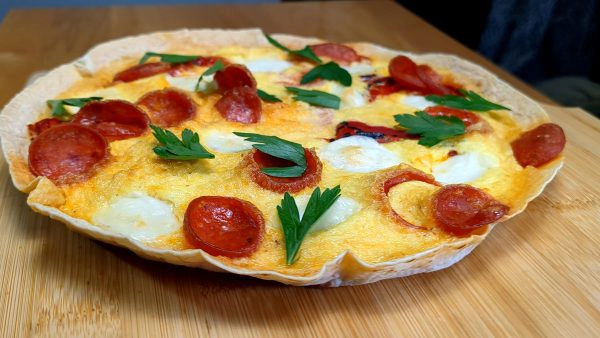 Egg tortilla pizza with fresh mozzarella, roasted red peppers, tomato, and pepperoni